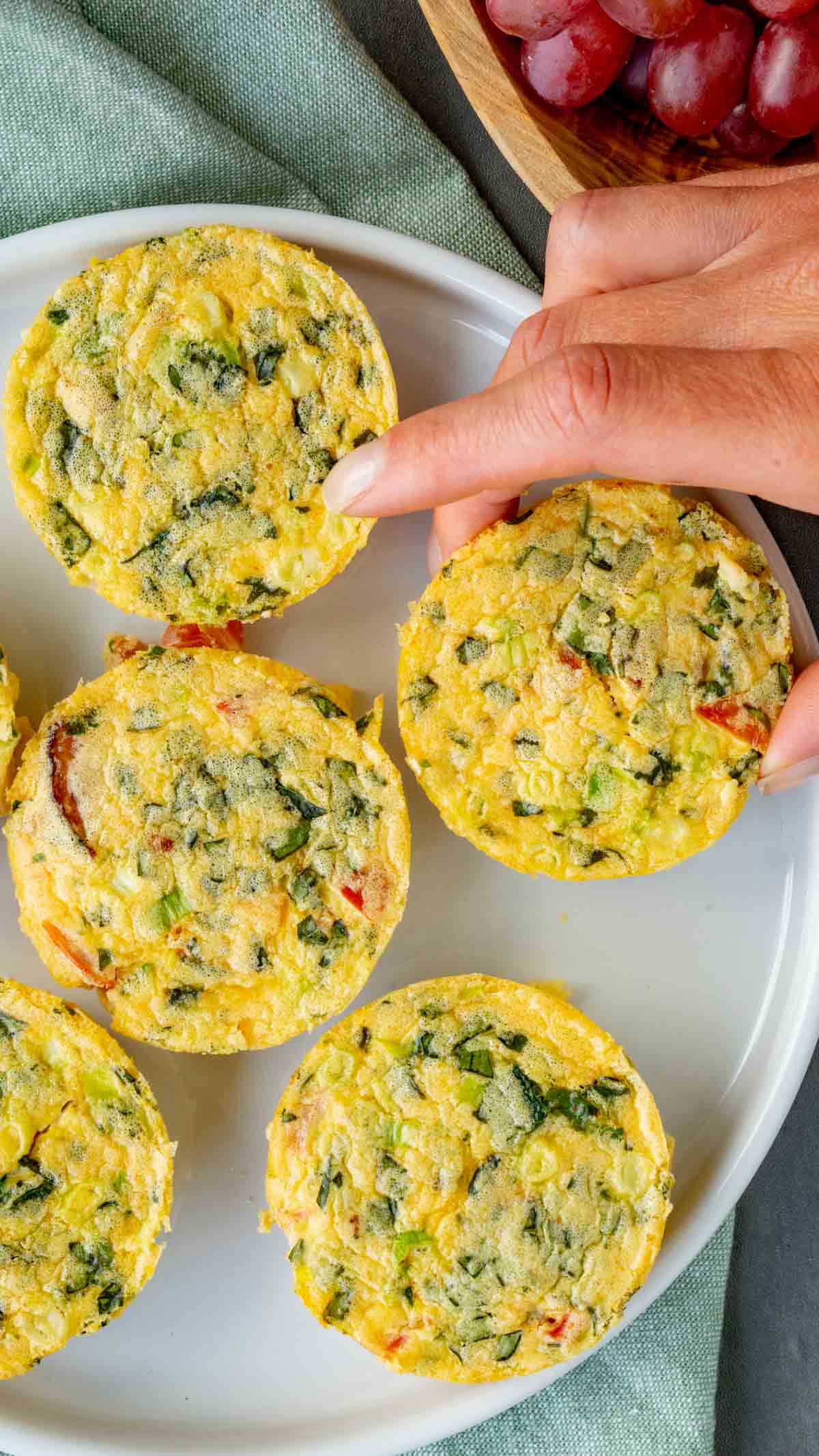 Cottage cheese Egg Bites on a white plate on top of a light sage green kitchen towel