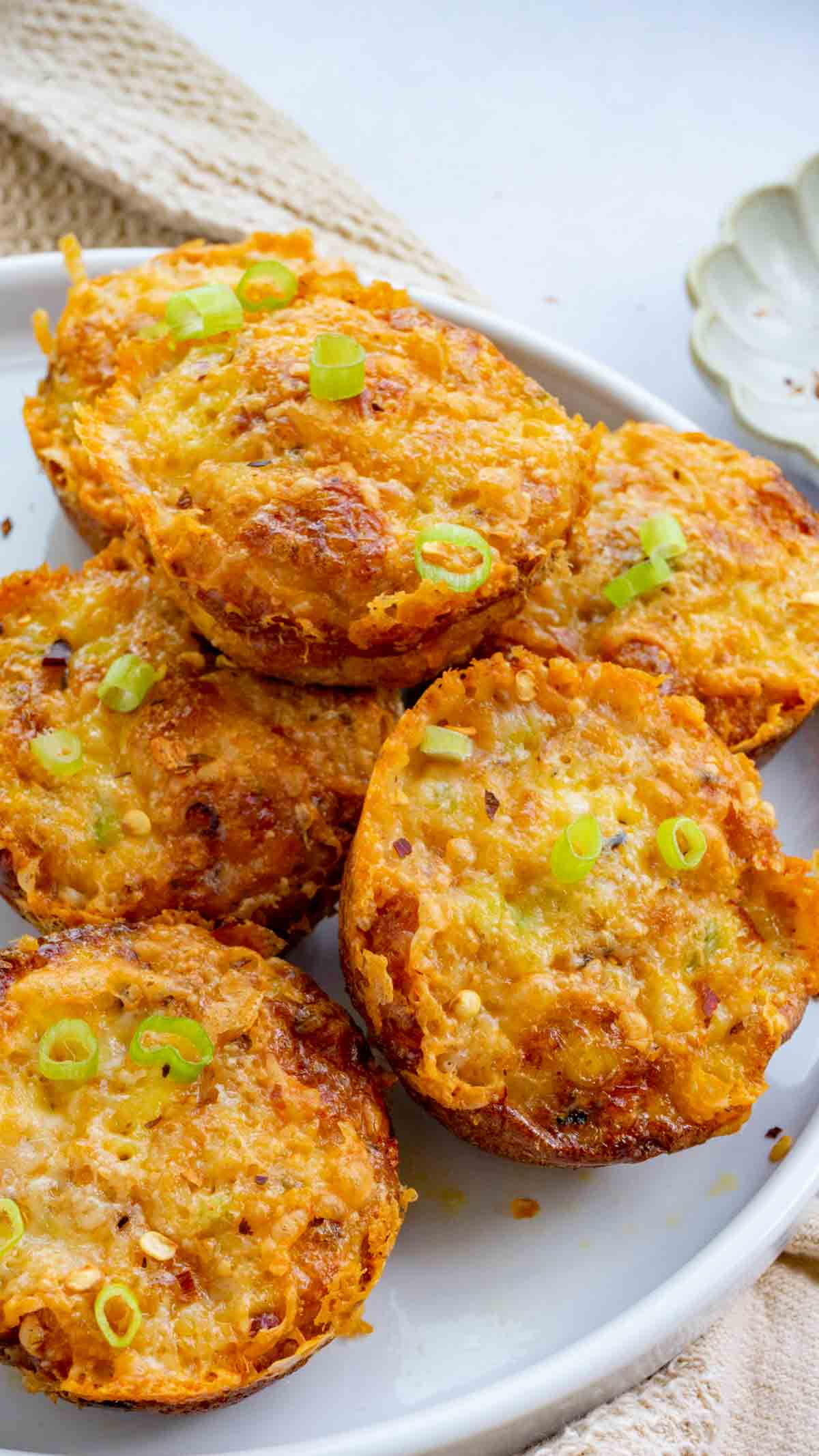 Sweet Potato Egg Bites on a white plate with red pepper flakes in a small bowl on the side